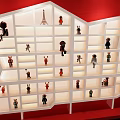 White Display Cabinet with Irregular Shelves Showcasing Small Figurines Against Red Background and Lit Compartments