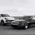 White SUV and Black Luxury Sedan Driving on Open Road Showcase Modern Vehicles