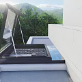 Detached Villa Open Black Frame Roof Skylight Overlooking Green Lawn Trees and Mountain Backdrop