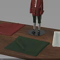 Mannequin In Red Coat And Green Pants With Fabric Pieces And Ruler On Wooden Table