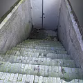 Mossy Broken Brick Stairs With Weathered Concrete Walls And Metal Door