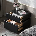 Black Leather Nightstand With White Vase Pink Flowers And Open Magazine By Bed