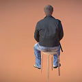Man sitting on chair wearing black leather jacket brown t-shirt ripped blue jeans gray shoes