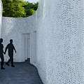 Perforated White Feature Wall In South Fountain Garden With Greenery And People Walking