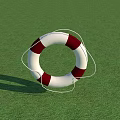 Red And White Lifebuoy As Commercial Safety Equipment Placed On Green Grass