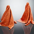 Two Orange Textured Towels Neatly Laid On Shiny Reflective Surface