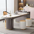 Modern Gray Desk with Laptop Gold Accents White Stools and Window View