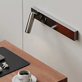 Sleek Modern Metal Wall Lamp Above Wooden Desk With Black Leather Pad And Illuminating Workspace