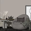 Curved Beige Single Sofa with Brown Pillows Striped Throw Blanket Stone Table and Minimalist Painting