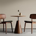 Wooden Table and Chair Set with Round Top Two Chairs Black Cushions Vase and Flower