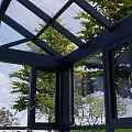 Outdoor Garden Patio Space With Black Glass Pavilion White Umbrella And Green Trees