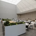 Modern Lounge Area Design With Green Plant Partitions Tables And Natural Light