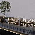 Modern Facade Entrance With LEGEND JUBILANT Golden Signage Gray Wall Trees And Waterfall