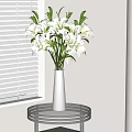 White Vase With Fresh White Lilies On Round Glass Table By Window Blinds