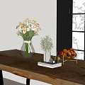 Transparent Vase With White Pink Flowers On Wooden Table With Green Plant And Fruit Bowl