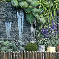 Lush Living Plant Wall With Colorful Flowers Waterfall Feature And Wooden Fence