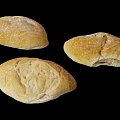 Three Freshly Baked Bread Loaves Isolated On Black Background