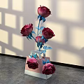 Stylish Floral Arrangement with Red Roses Blue Stems Leaves in Pink White Vase Light Wall