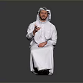 Man Sitting And Smiling In White Traditional Clothing With Headscarf Gesturing Against Gray Background