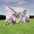 Outdoor Floral Installation With Purple White Flowers Green Grass And Blue Sky Backdrop