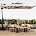 Wicker Outdoor Chairs With Round Table And Umbrella On Wooden Deck With Green Plants