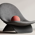 Modern Curved Gray Accent Chair With Red Sphere On Light Colored Wall And Wooden Floor