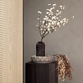 White Flowers in Textured Black Vase on Small Wooden Table with Decorative Brown Branches