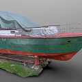 Green and Red Hull Yacht Covered with Tarpaulin on Stands in Grass Area