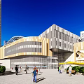 Modern Commercial Complex With Glass Curtain Wall Pedestrian Activity And Urban Greenery