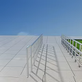 Outdoor Metal Railings Along Building Ramp with Green Grass and Gray Tiles