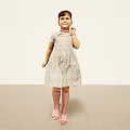 Little Girl Standing in Light Background Wearing Gray Dress Pink Socks and Pink Shoes