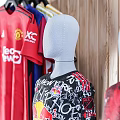 Different Football Team Jerseys Displayed On Mannequins And Hanging On Wooden Wall