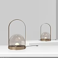 Two Modern Table Lamps With Metal Frame And Glass Globe Shade Illuminated On Shelf