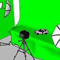 Green Screen Studio Setup with Studio Lights Umbrellas Camera Tripod and Toy Car