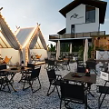 Modern Teahouse Outdoor Area With White Tents Greenery Tables Chairs And String Lights