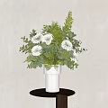 Decorative Ornament Set With White Vase White Flowers Green Leaves On Small Brown Round Table