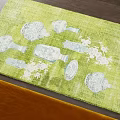 Green Square Rug With White Vase Plate And Flower Patterns On Dark Floor