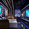 Modern KTV Interior Design With Blue Lighting Large Screen TV Sofa And Reflective Floor