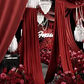 Wedding Floral Display With Red Curtains Crystal Chandeliers And Pink Red Flowers On Black Stage