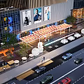 Modern Commercial Street With Glass Buildings Billboards Outdoor Seating Vehicles And Pedestrians