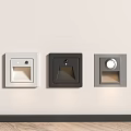 Three Different Colored Square Wall Lights Installed On Light Colored Wall With Wooden Floor