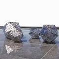 Metallic Polyhedral Landscape Sculptures With Hollowed Patterns On Sleek Ground And Reflections