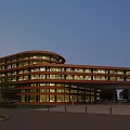 Modern Commercial Complex With Curved Glass Facade And Illuminated Exterior Surrounded By Plaza And Trees