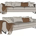 Beige Three Seater Sofa With White Brown Light Gray Cushions And Brown Tassel Blanket