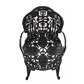 Ornate Metal Chair With Intricate Carved Patterns And Decorative Armrests