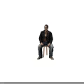Man sitting on chair wearing black leather jacket brown t-shirt ripped blue jeans gray shoes