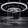 Modern Stage Setup With PEVON Sign Circular Light Installation Wavy Background And Yellow Motorcycle