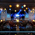 Modern Bar Interior with Colorful Spherical Pendant Lights Stage Tables Chairs and Lighting Effects