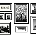 Black And White Photo Wall With Various Sized Frames Arranged On White Wall