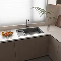 Modern Kitchen Countertop With Gray Sink Faucet Glass Bowl Of Oranges And Wooden Cabinets